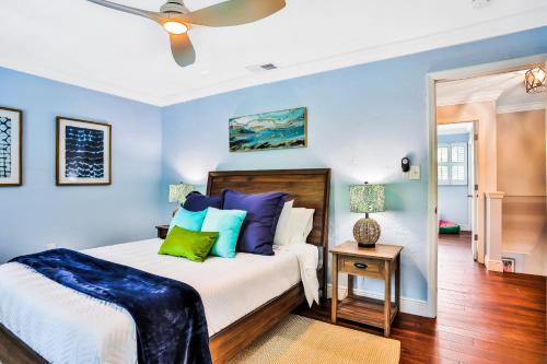 1 dormitorio con paredes azules y 1 cama con almohadas coloridas en Flamingo Cottage en New Smyrna Beach