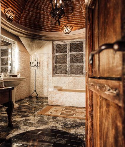 a bathroom with a tub and a sink at Meson Panza Verde in Antigua Guatemala