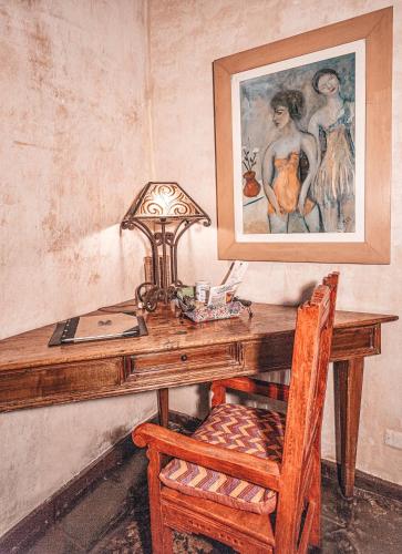 a wooden desk with a chair and a picture at Meson Panza Verde in Antigua Guatemala