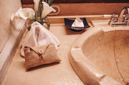 a bathroom sink with a towel on the edge of it at Meson Panza Verde in Antigua Guatemala