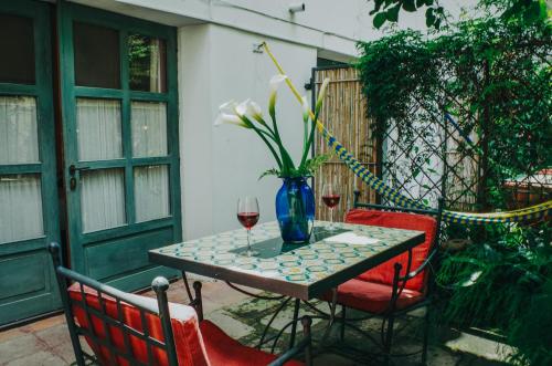 a table with a vase of flowers and a glass of wine at Meson Panza Verde in Antigua Guatemala