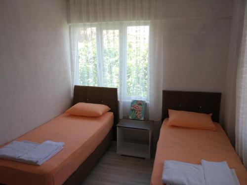 two beds in a room with a window at Salda Lake Sagiroglu Apart in Gökçe