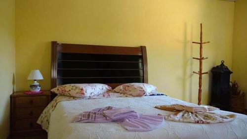a bedroom with a bed with clothes on it at Chalés pouso do vale in Visconde De Maua