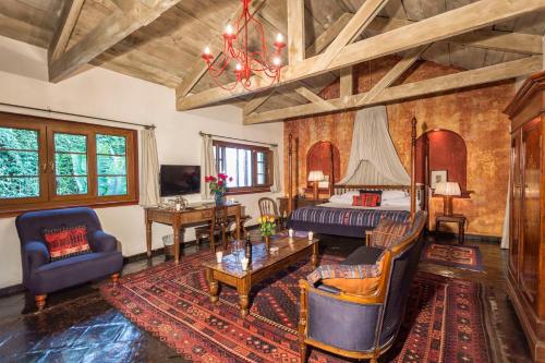a living room with a bed and a table at Meson Panza Verde in Antigua Guatemala