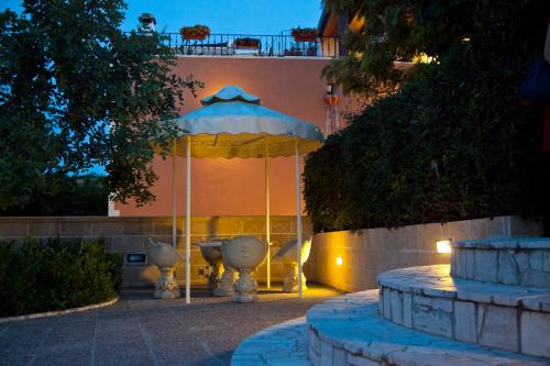 a patio with an umbrella in front of a building at Villa Musica in Sannicola