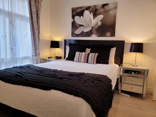 a bedroom with a large bed with a flower painting on the wall at MacArthur Chambers in Brisbane