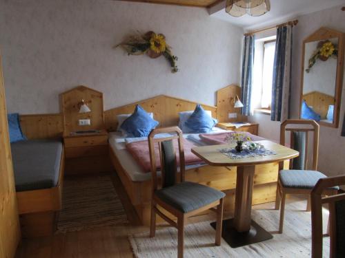 um quarto com uma cama, uma mesa e cadeiras em Landhaus Neubauer - Zimmer em Millstatt