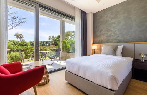 a bedroom with a bed and a large window at The Grand Sumorum in Seogwipo