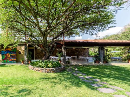a house with a tree in the yard at Hotel Amate del Rio in Malinalco