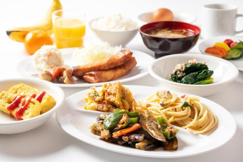 a white table with plates of food on it at セントラルホテル磯原 in Isohara