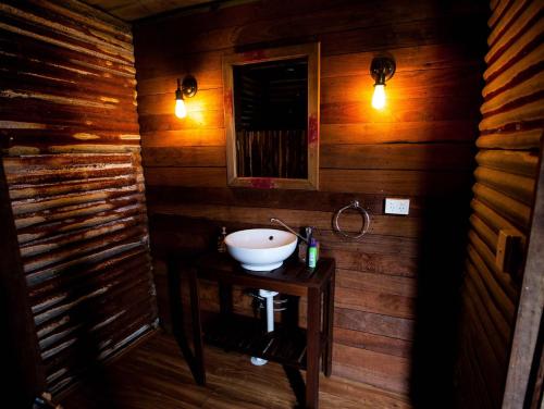 uma casa de banho com um lavatório numa parede de madeira em Boogaloo Camp em Augusta