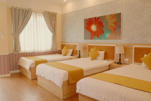 a hotel room with two beds and a window at Sao Vang Hotel in Bao Loc
