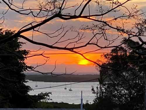 a sunset over a body of water with boats at J & Ella's Holiday House - 2 Bedroom Stays in Cooktown