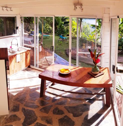 a kitchen and living room with a wooden table at HUAHINE Manta Lodge avec 4x4 optionnel in Haapu