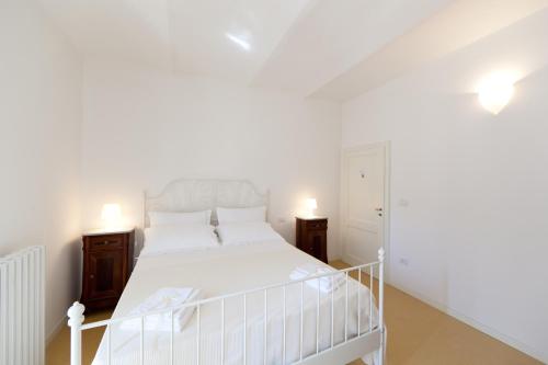 a bedroom with a white bed and two night stands at Guest Apartament Clarice in Capodacqua di Foligno