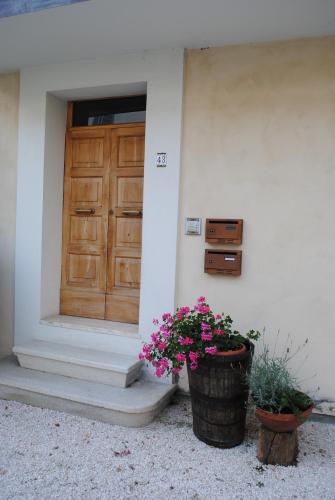 a front door of a house with two pots of flowers at Guest Apartament Clarice in Capodacqua di Foligno