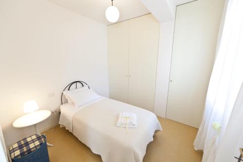 a white room with a bed and a table at Guest Apartament Clarice in Capodacqua di Foligno