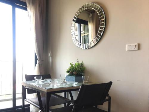 a dining room table with a mirror on the wall at Many Holiday The Base Condo in Pattaya Central