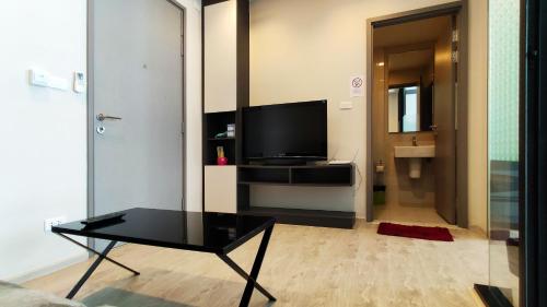 a living room with a tv and a black coffee table at Many Holiday The Base Condo in Pattaya Central