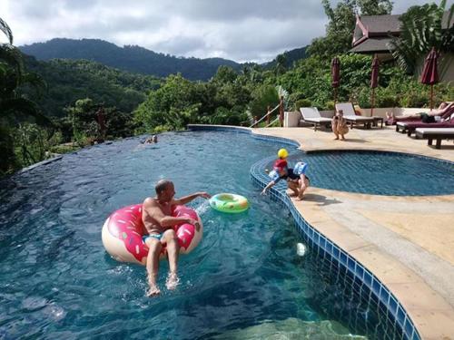 Un uomo su una camera d'aria in una piscina di Koh Phangan Pavilions Serviced Apartments a Thong Nai Pan Noi