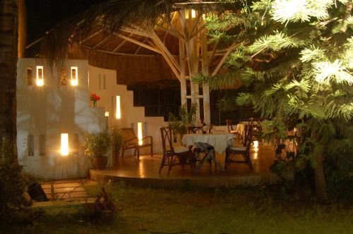 a patio with a table and chairs at night at The Meadows Resort and Spa in Aurangabad