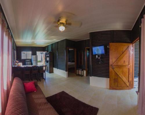 a living room with a couch and a kitchen at Cabaña El Monasterio in Fortuna