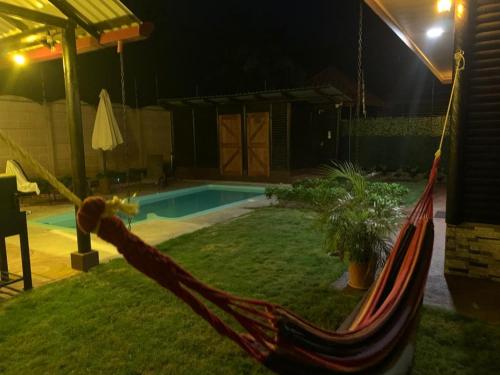 a hammock in front of a pool at night at Cabaña El Monasterio in Fortuna