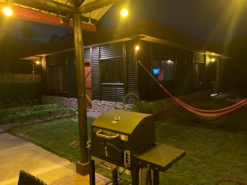 a grill in front of a house at night at Cabaña El Monasterio in Fortuna