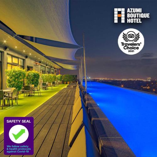 a night view of a hotel with a swimming pool at Azumi Boutique Hotel in Manila