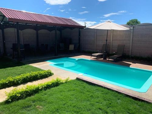 a swimming pool in a yard with an umbrella at Cabaña El Monasterio in Fortuna