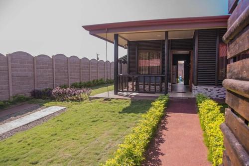 a house with a grassy yard next to a building at Cabaña El Monasterio in Fortuna