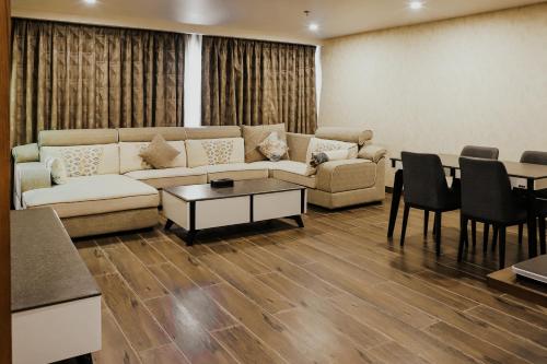 a living room with a couch and a table and chairs at Regenta Central Somnath, Bhalpara in Somnath