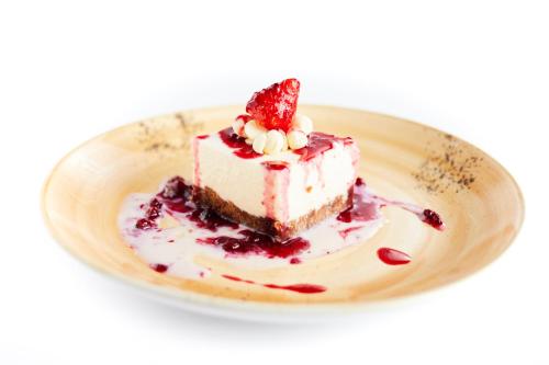 a piece of cake with a strawberry on a plate at LHP Hotel Certaldo in Certaldo