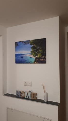 a picture hanging on a white wall with a shelf at Sarah klein aber fein in Wellesweiler