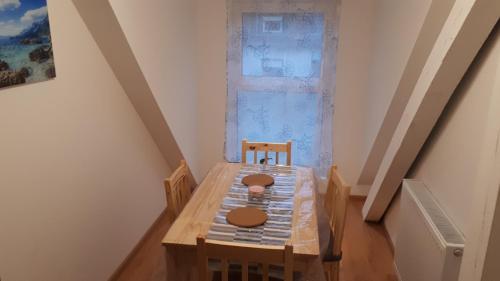 a wooden table and chairs in a room with a window at Sarah klein aber fein in Wellesweiler