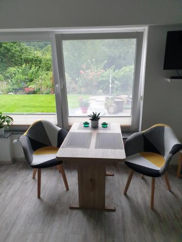 uma mesa e cadeiras num quarto com uma janela em Evia Ferienwohnung em Heimbach