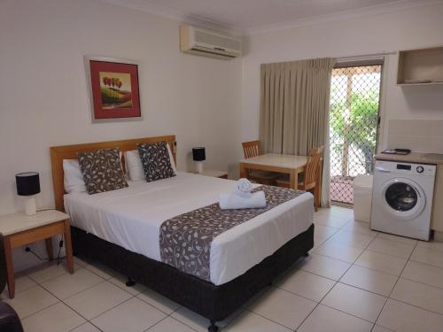 a bedroom with a bed and a washing machine at Cascade Motel In Townsville in Townsville