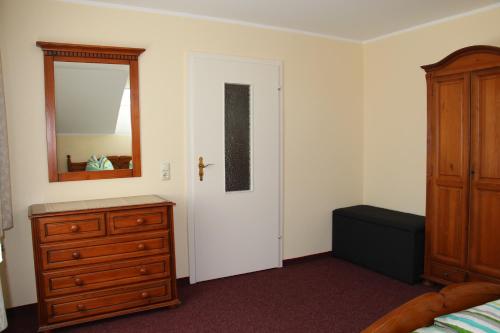 a bedroom with a bed and a dresser and a mirror at Ferienwohnung Oleanderhof in Zossen