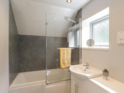 ein Badezimmer mit einer weißen Badewanne und einem Waschbecken in der Unterkunft Fauna's Corner in Whitby