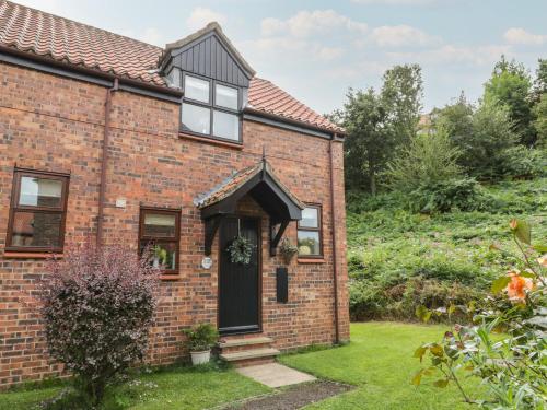 an old brick house with a black door at Fauna's Corner in Whitby