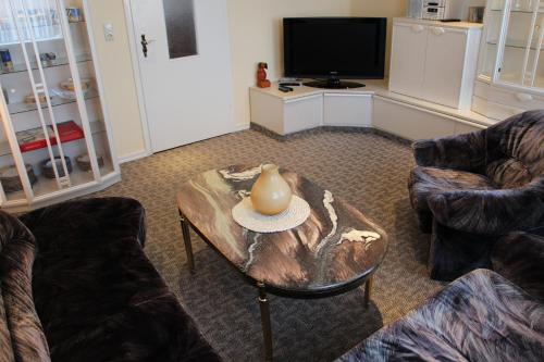 a living room with a table with a vase on it at Ferienwohnung Oleanderhof in Zossen