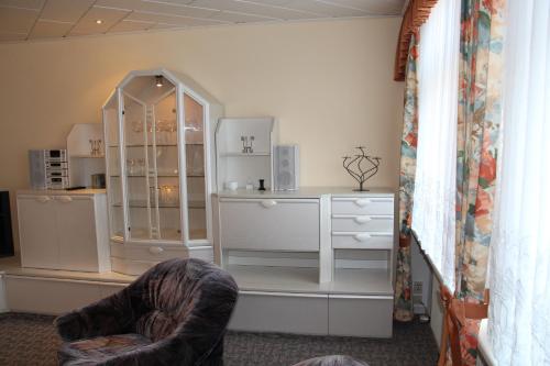 una habitación con un armario de porcelana y una silla en Ferienwohnung Oleanderhof, en Zossen