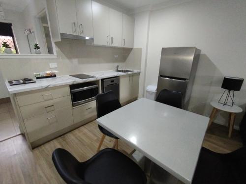 a kitchen with a table and chairs and a refrigerator at Cascade Motel In Townsville in Townsville