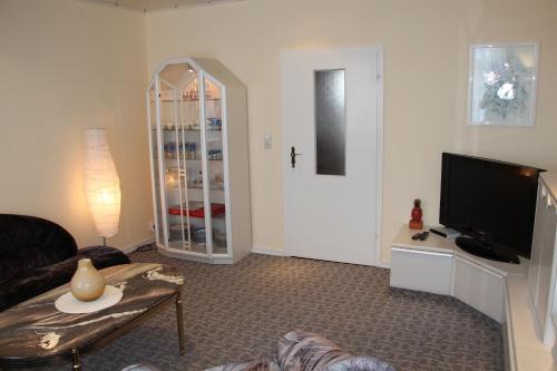 a living room with a flat screen tv and a couch at Ferienwohnung Oleanderhof in Zossen