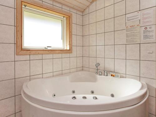 a bath tub in a bathroom with a window at 10 person holiday home in V ggerl se in Marielyst