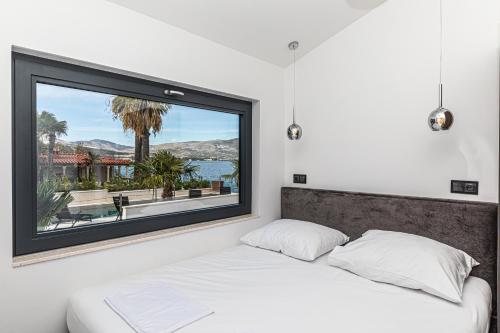 a bedroom with a bed with a large window at Villa Sun and Sea in Trogir