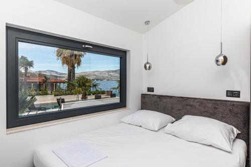 une chambre avec un lit et une grande fenêtre dans l'établissement Villa Sun and Sea, à Trogir