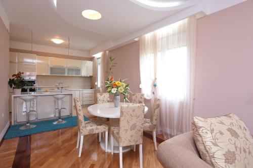a kitchen and living room with a table and chairs at Apartments Aleksandra in Podgorica
