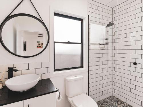 a bathroom with a toilet and a sink and a mirror at Poplar Villa - 1 Poplar Lane in Evans Head