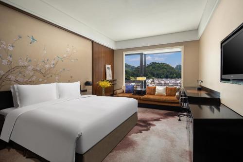 - une chambre avec un grand lit blanc et une grande fenêtre dans l'établissement Crowne Plaza Huangshan Yucheng, an IHG Hotel, à Huangshan